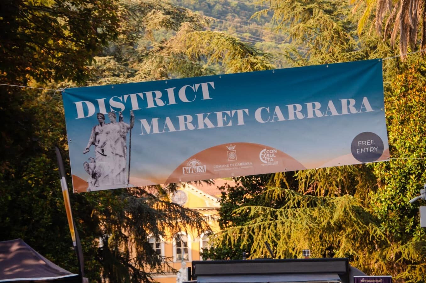 Il banner d'ingresso del District Market 2024 con le Apuane sullo sfondo