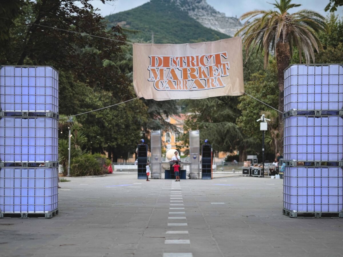 L'ingresso del District Market 2026, con le torri luminose e le Apuane